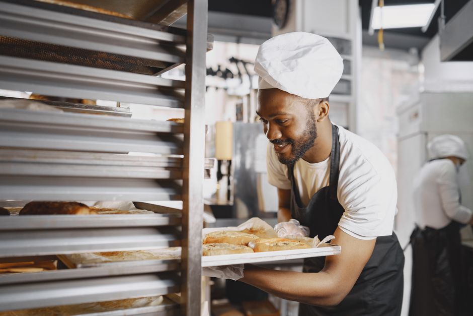Professional pastry chef working at bakery station, focused on craft