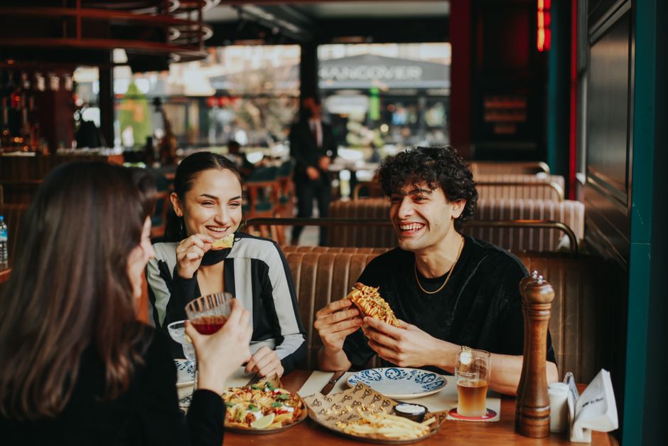 Diners enjoying meals together at a restaurant table in a community setting